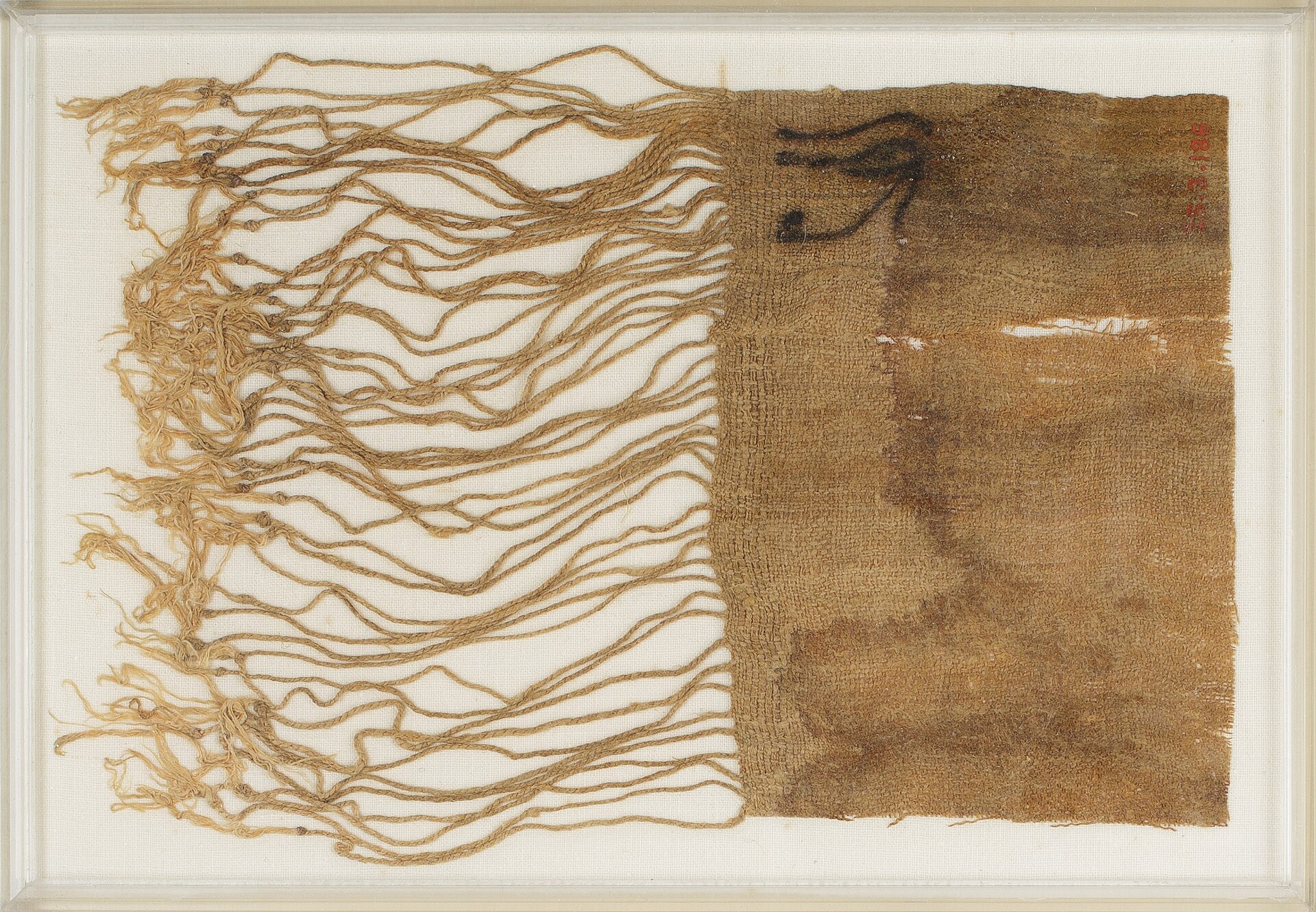 A square of fine ancient Egyptian linen with a long fringe, marked with an eye drawn in dark ink