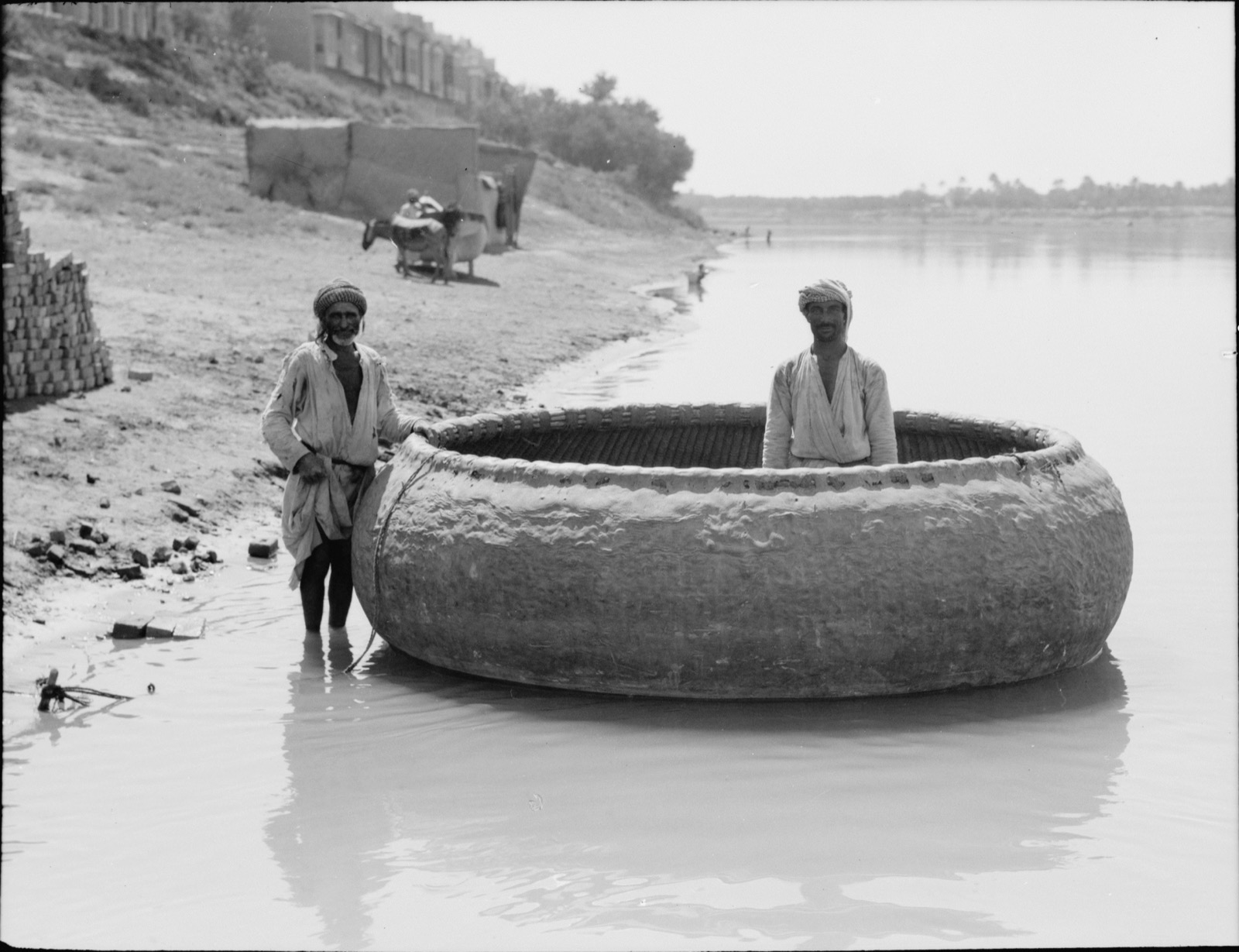 A guffa, a large round woven boat, on the Tigris at Baghdad in 1932, with people aboard