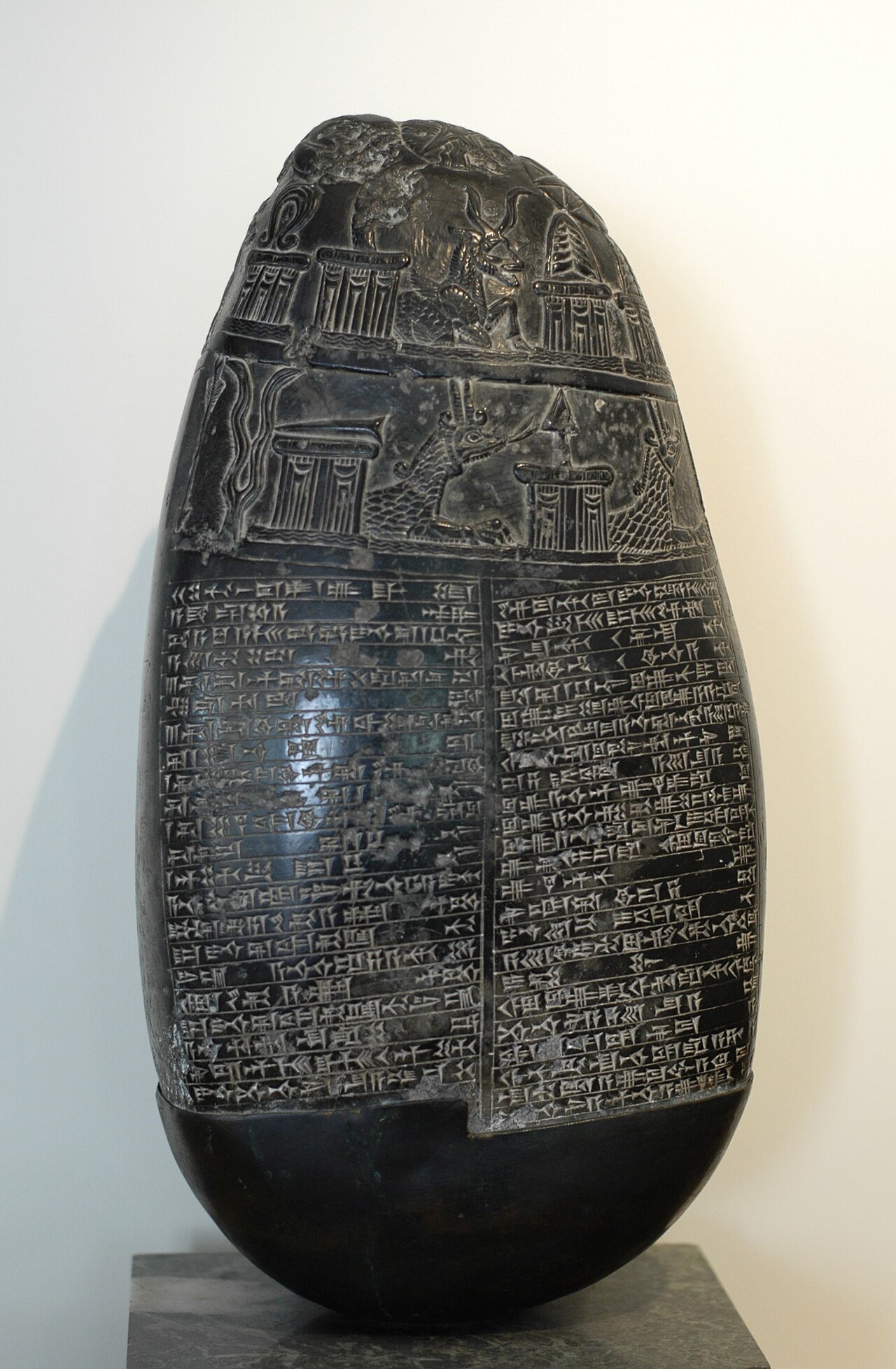 A Babylonian boundary stone carved with rows of symbols and lines of cuneiform text