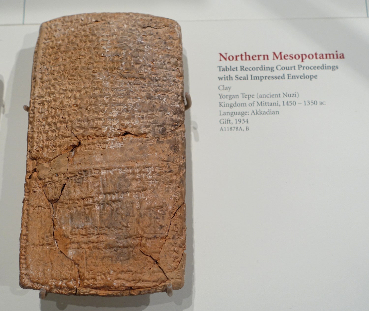 A clay tablet inscribed in Akkadian beside its seal-impressed clay envelope