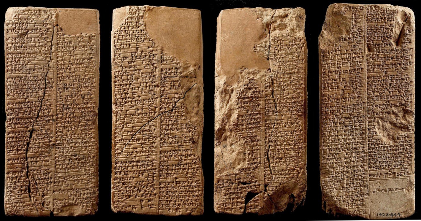 Four photographed faces of a four-sided clay prism, each covered in columns of cuneiform writing
